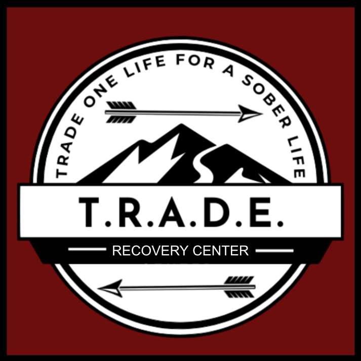 Logo of T.R.A.D.E. Recovery Center with mountain and arrow design.