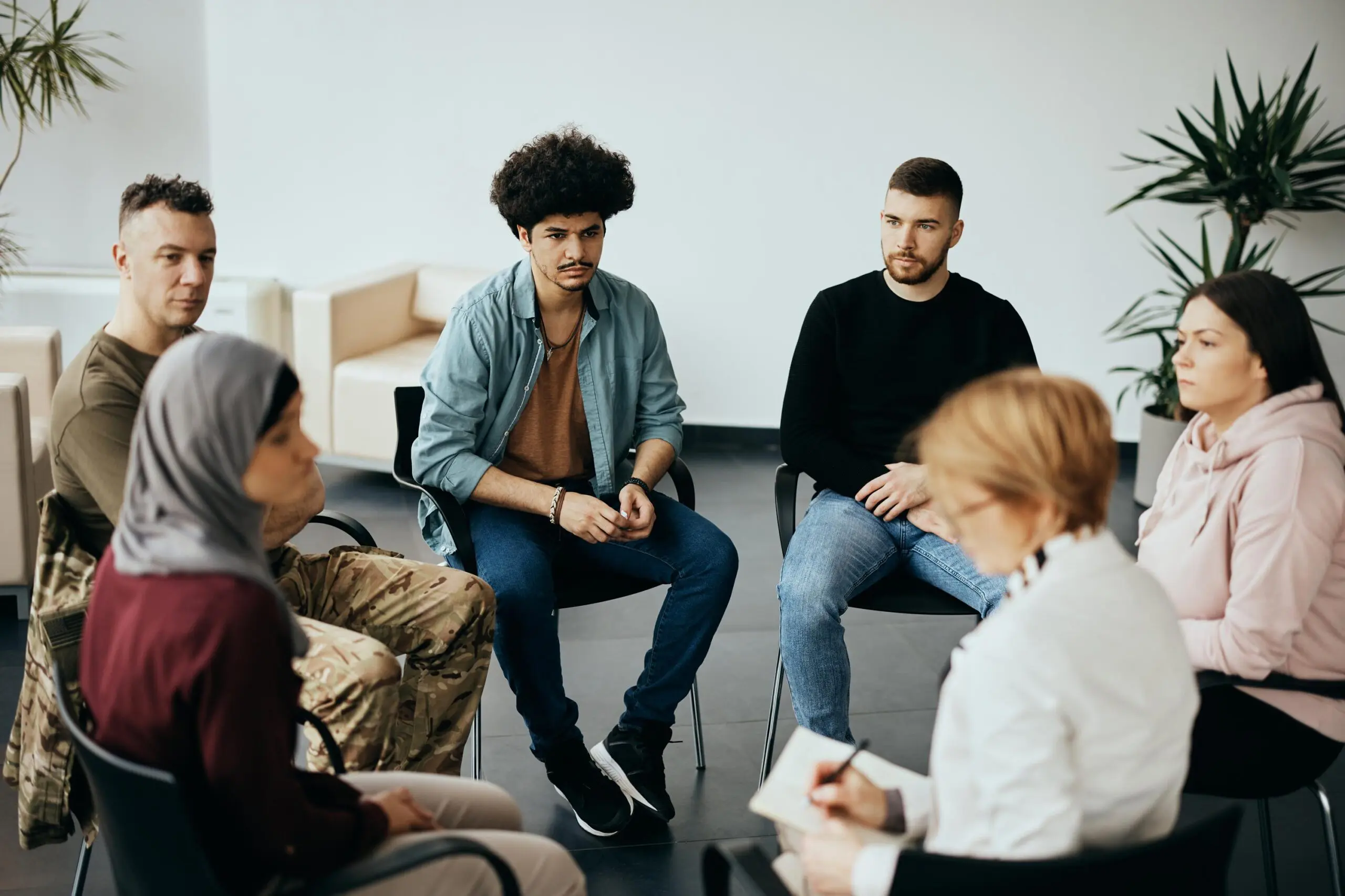 A group of young adults engaged in a discussion in a cozy room.