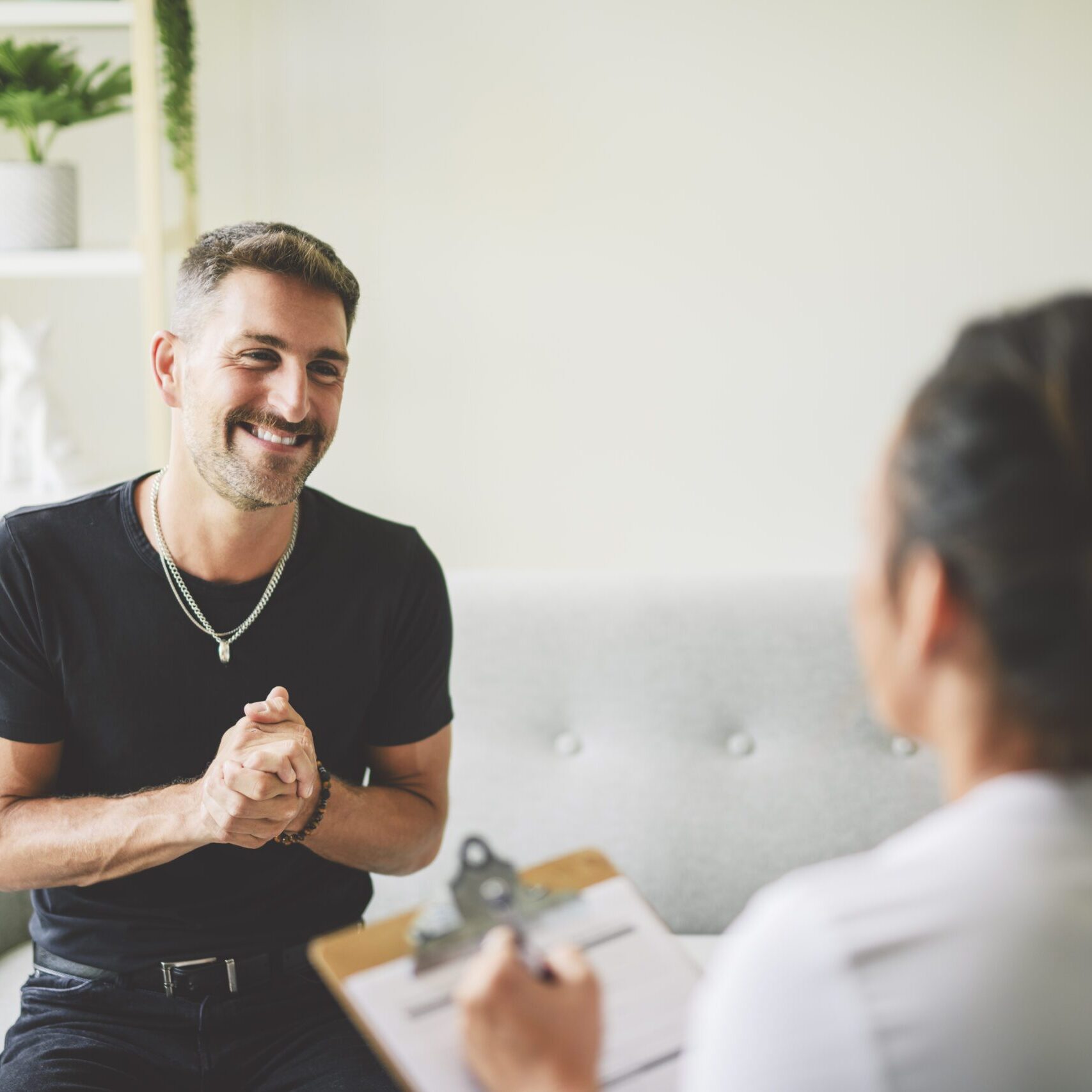 A man smiling and engaging in conversation during a consultation.